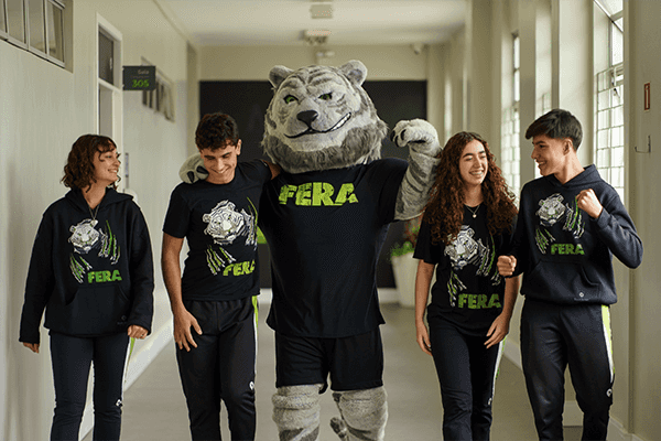 adolescentes no corredor junto com o mascote do canal fera